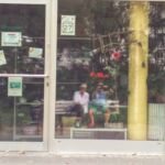 Wir spiegeln uns im Schaufenster einer Boutique, auf einer Bank am Boulevard in Lütten-Klein sitzend.